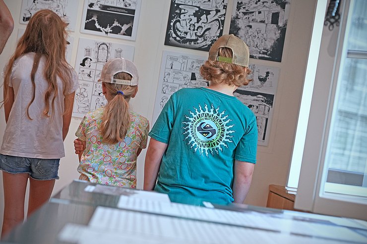 © Land Tirol Zwei Kinder stehen vor Bildern der Graphic Novel in der Ausstellung