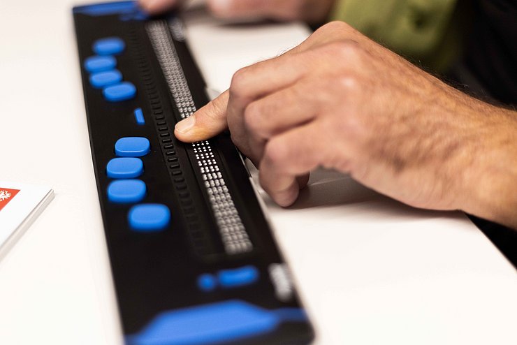Braillezeile mit Hand