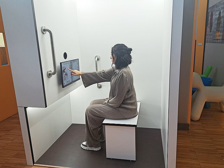 Ein Frau bedient einen Monitor in einer Fotobox.