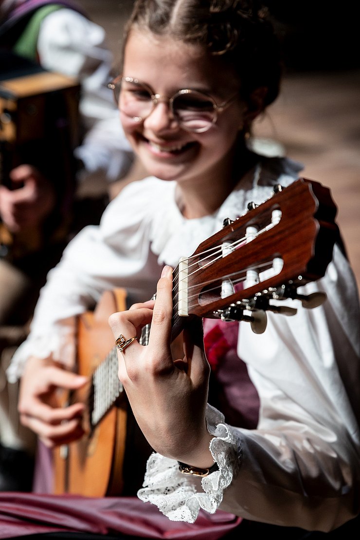 Ein Mädchen spielt Gitarre.