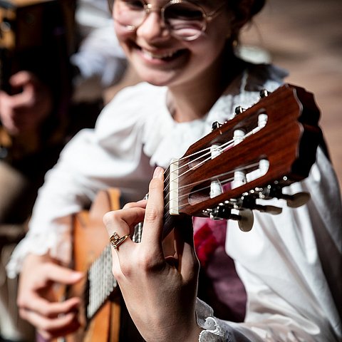 Ein Mädchen spielt Gitarre.