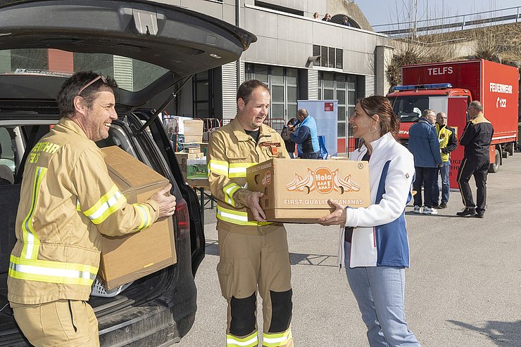 Frau, die ein Paket bei den Feuerwehren abgibt.
