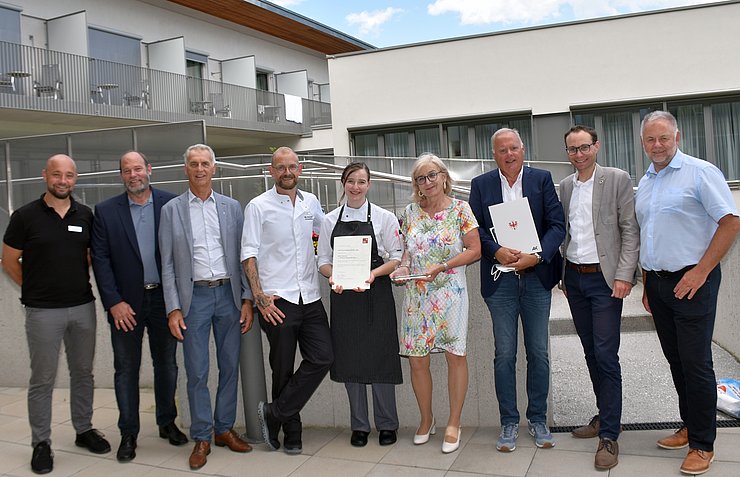 Gruppenfoto v. li. Christian Elzinger (Verwaltungsdirektor Reha-Zentrum Münster), Ben Wechselberger (Vize-Bgm Gemeinde Weerberg), Wolfgang Schonner (Obmann Wirtschaftskammer Kufstein), Nils Wunderlich (Lehrlingsausbilder Reha-Zentrum Münster), „Lehrling des Monats Juni 2022“ Kathrin Sponring, Arbeits- und Bildungslandesrätin Beate Palfrader, Werner Salzburger (Kammerrat Arbeiterkammer Tirol), Thomas Mai (Bgm Gemeinde Münster) und Lorenz Hohenauer (Geschäftsführer Reha-Zentrum Münster).  