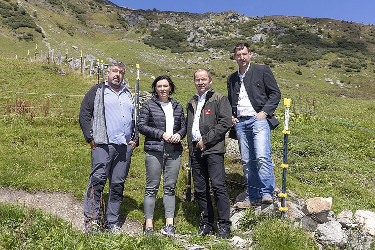 BU: Beim Lokalaugenschein von Herdenschutzmaßnahmen auf der Peer-Alm in Navis: v.l. Christian Löffler, der den Schutzzaun errichtet hat, BMin Elisabeth Köstinger, LHStv Josef Geisler und der Naviser Bgm Lukas Peer.  