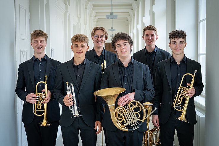 © Land Tirol/Neuner Die jungen Musiker stehen in einem weißen Gang.