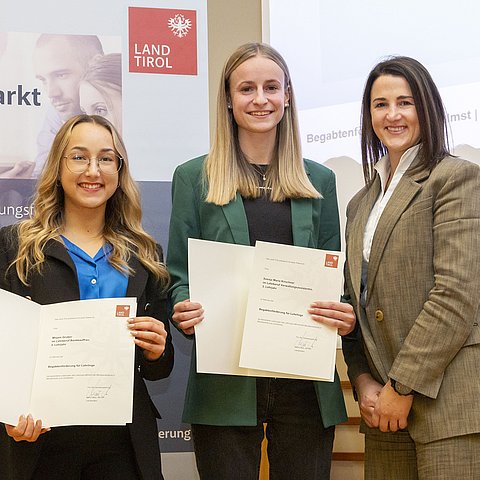 Eine stehende Dreiergruppe: Die beiden bestausgezeichneten Lehrlinge Mirjam Gruber (Bankkauffrau 3. Lehrjahr), Svenja Maria  Kirschner (Verwaltungsassistentin 3. Lehrjahr) mit LRin Astrid Mair (von links).