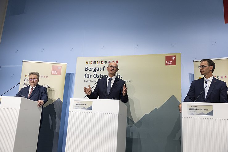 © Land Tirol/Sedlak Mattle bei PK sprechend, Ludwig und Wallner daneben hinter Rednerpulten stehend