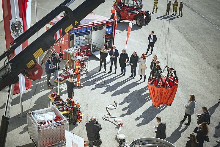 Zuschauer betrachten Kran mit Wasserbehälter