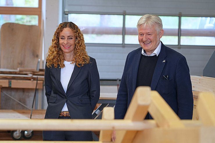 Zwei Menschen begutachten ein Holzstück.
