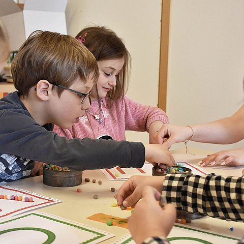 Foto von Kindern an einem Tisch die etwas basteln.