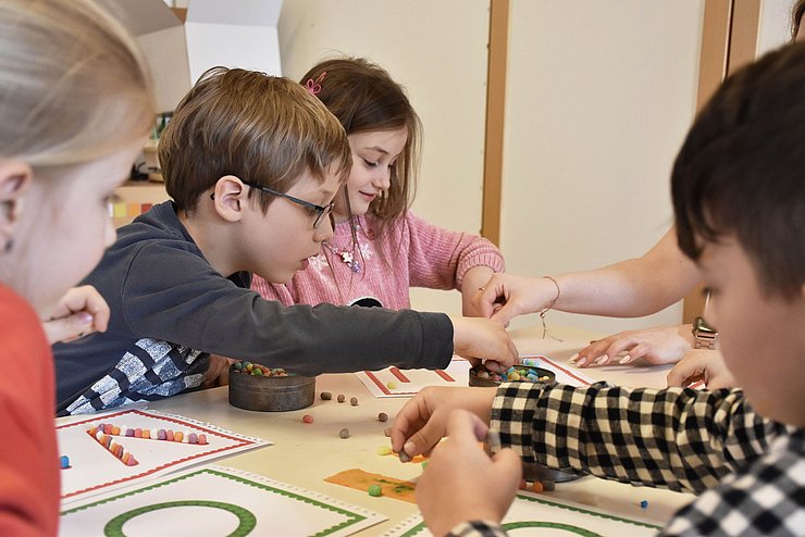 Foto von Kindern an einem Tisch die etwas basteln.