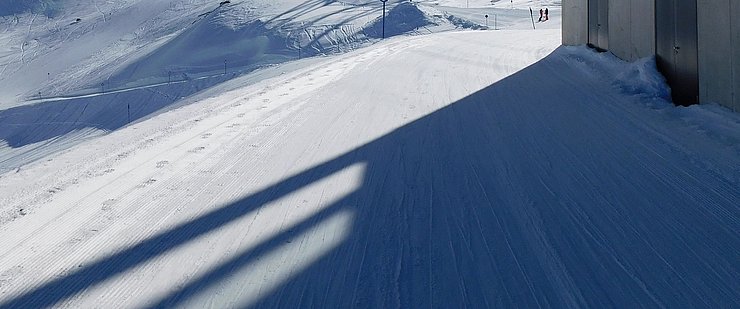 © DI Martin Schönherr, Abt. Raumordnung und Statistik Schnee, Schispuren, Schatten einer Seilbahnstütze, im Vordergrund Seilbahnstation