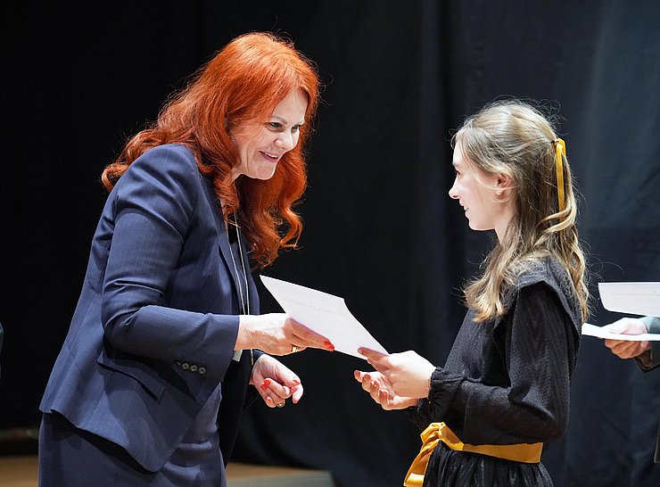 © Land Tirol/Neuner Landesrätin Hagele überreicht einem Mädchen eine Urkunde.