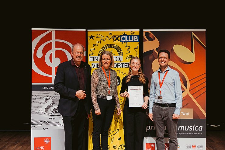 Vier Personen stehen vor Roll-ups.