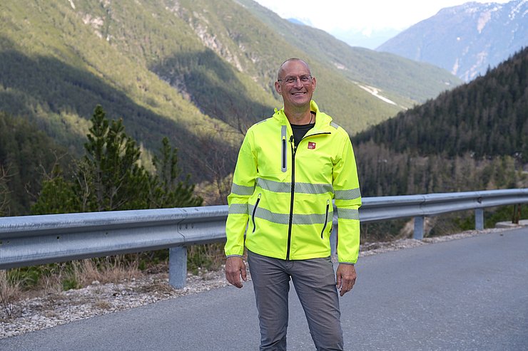 Mann in gelber Warnjacke auf Passstraße