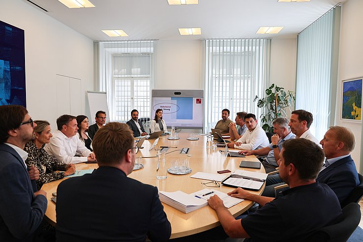 © Land Tirol/Wurnig Mehrere Personen um runden Tisch sitzend