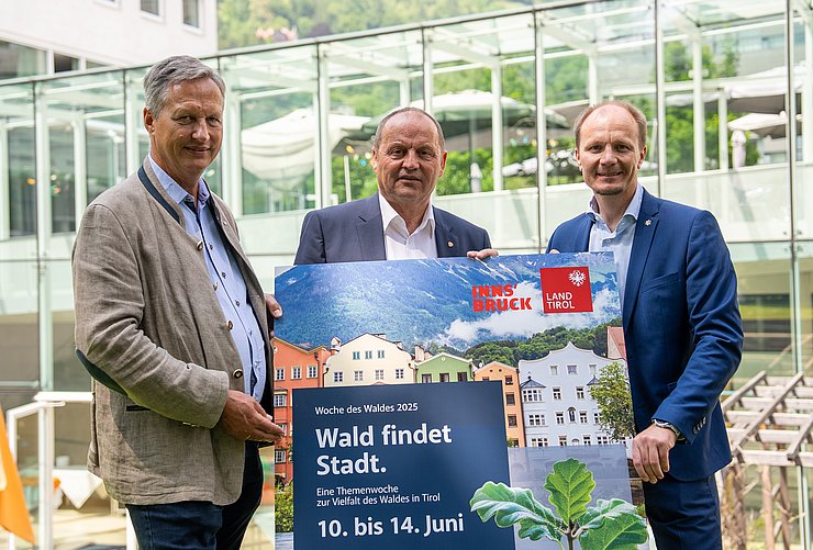 Personen stehen nebeneinander, halten Schild hoch