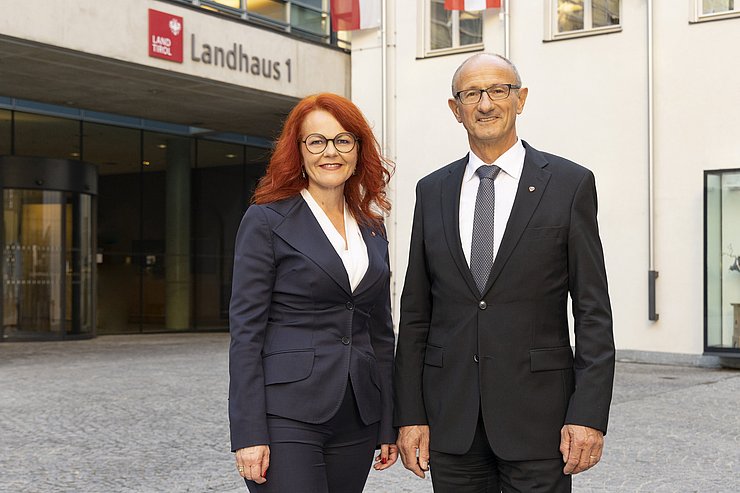 © Land Tirol/Die Fotografen Hagele und Mattle stehen vor dem Eingang ins Landhaus beim Meraner Innenhof.
