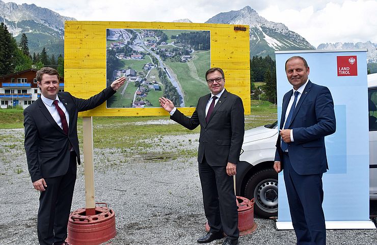 Bürgermeister Christian Tschugg, Landeshauptmann Günther Platter und Landeshauptmann-Stellvertreter Josef Geisler zeigen auf einen Plan des Projekts.