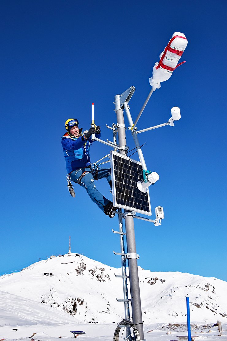 Station auf schneebedecktem Gipfel - mit Mann oben