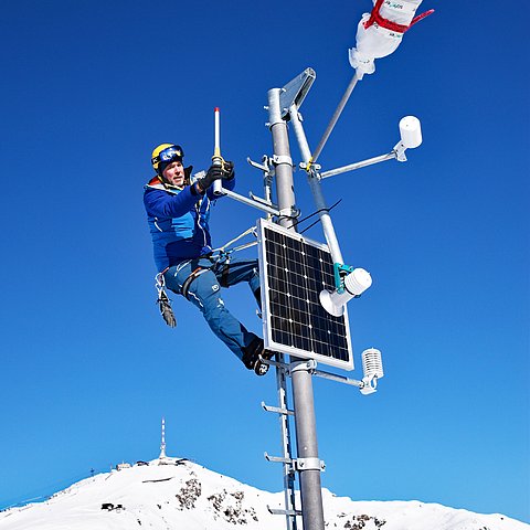 Station auf schneebedecktem Gipfel - mit Mann oben