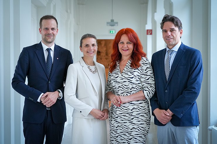 © Land Tirol/Neuner Zwei Männer und zwei Frauen stehen in einem weißen Gang.