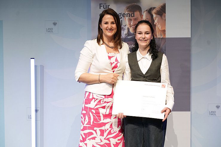 © Land Tirol/Trenker Jugendliche mit Urkunde und eine Frau auf der Bühne