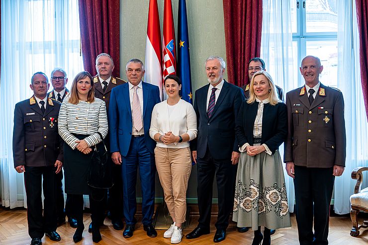 Gruppenfoto; im Hintergrund Fahnen von Österreich, Kroatien und der EU