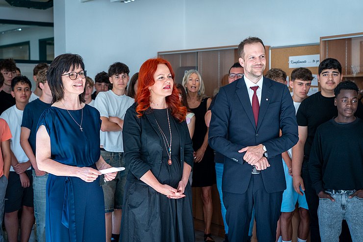 © Land Tirol/Schallhart Die Landesrätin steht mit zwei Erwachsenen in einer Schulklasse.