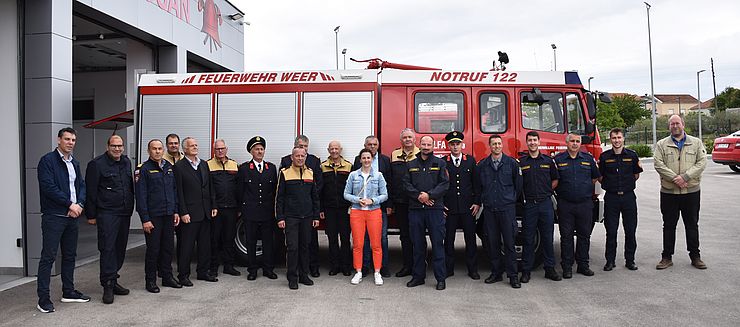 Landesrätin Mair gemeinsam mit Vertretern der Feuerwehren Tirol und Zadar vor dem Feuerwehrwagen.