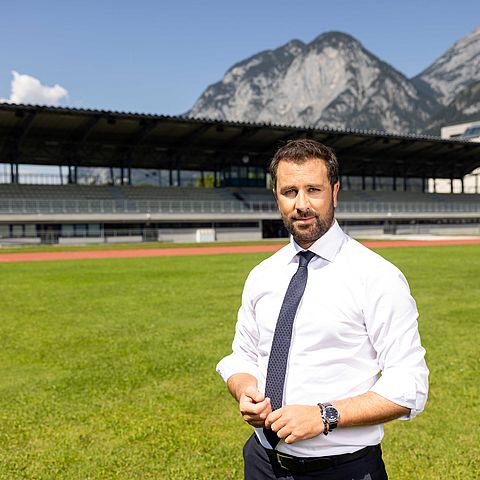 Landeshauptmannstellvertreter Georg Dornauer auf einem Fußballfeld und im Hintergrund die Tribünen
