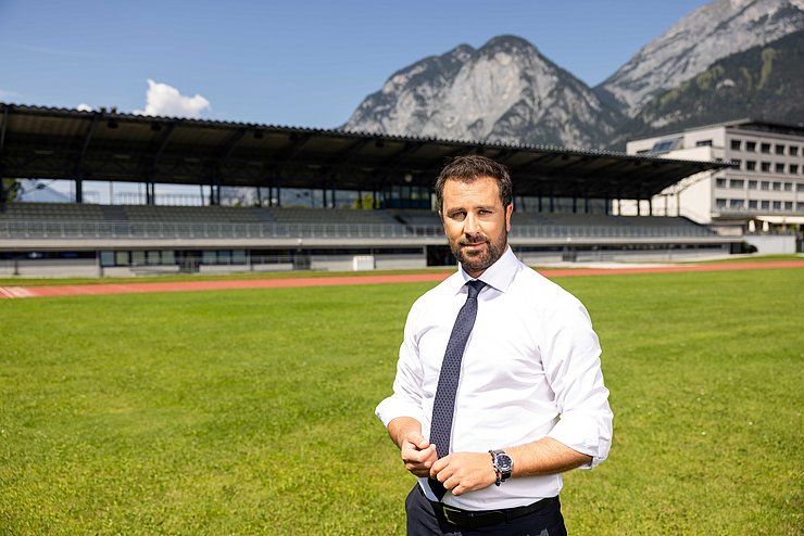 Landeshauptmannstellvertreter Georg Dornauer auf einem Fußballfeld und im Hintergrund die Tribünen