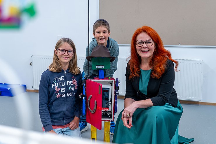 Das STEAM-Lab, ein neues Lernlabor im Pflichtschulzentrum Wörgl, wurde heute der breiten Öffentlichkeit präsentiert (im Bild: LRin Hagele mit der Erbauerin und dem Erbauer von „Robobert“).