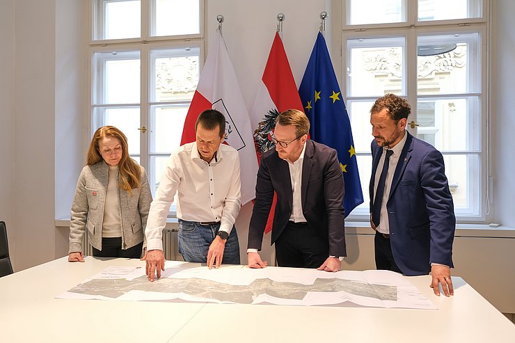 Helga Beermeister, Günter Guglberger, Landeshauptmannstellvertreter Philip Wohlgemuth und Florian Riedl in einem Büro beim Besprechen der Pläne für die Radroute im Wipptal