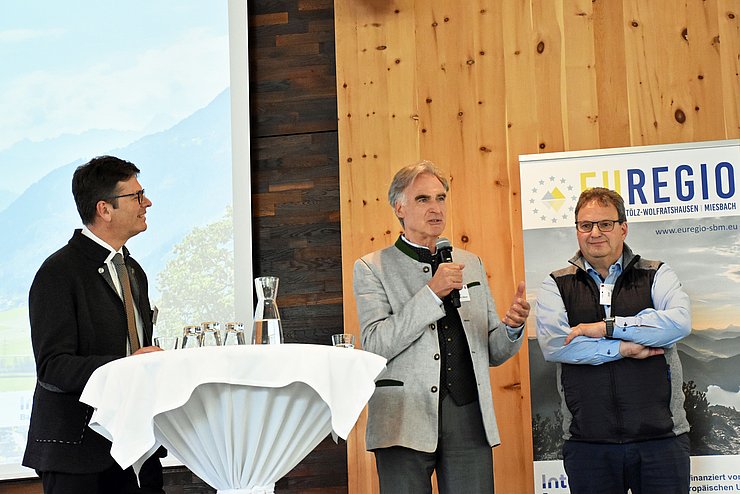 Brandl, von Löwis of Menar und Niedermaier auf Bühne stehend, Löwis of Menar mit Mikrofon in der Hand sprechend