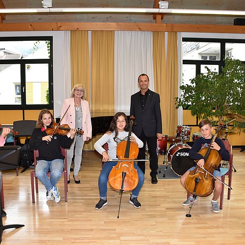 V. li. die Streichergruppe mit Josef Moser, Clara Zobl, Aylin Karokoc, Nepomuk Sommavilla und Maximilian Tschaffert und in der Reihe dahinter v. li. Landesmusikdirektor Helmut Schmid und Kulturlandesrätin Beate Palfrader in der Landesmusikschule Schwaz. 