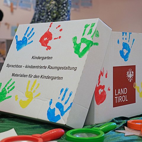 Die Sprachboxen beinhalten Kärtchen und Materialien (z. B. Lupen oder Knetmasse), die Impulse für die Sprachförderung geben.