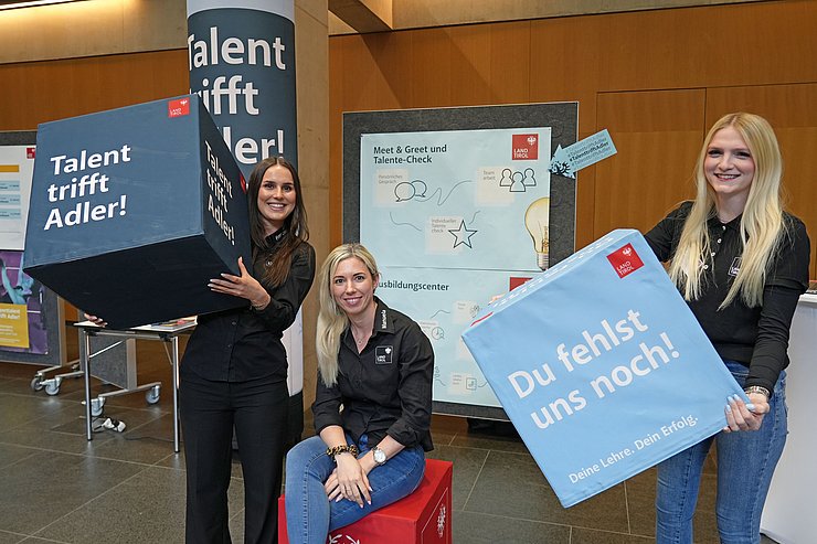 Mehrere Frauen halten Boxen in die Höhe.