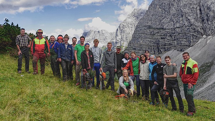 Gruppenfoto auf der Alm mit Bergen im Hintergrund