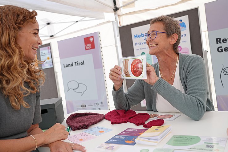 © Land Tirol/Dorfmann Expertin hält Bild hoch, Landesrätin schaut