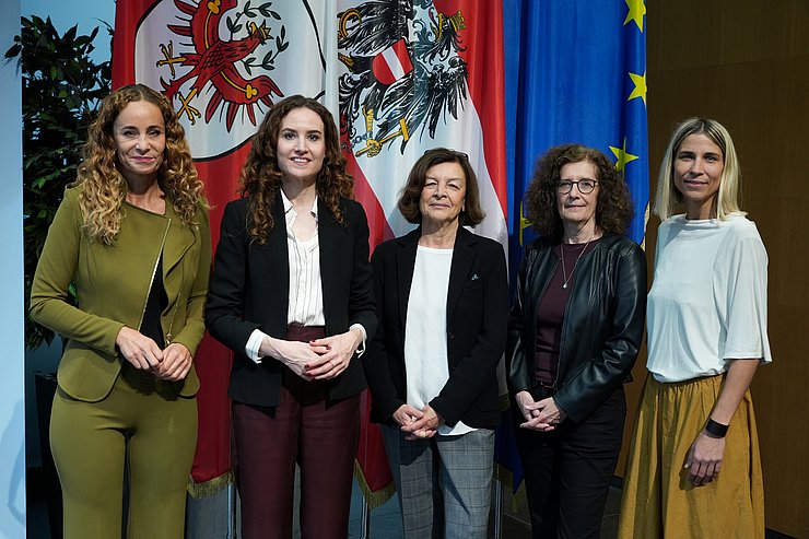 © Land Tirol/Saxl Fünf Frauen stehen nebeneinander vor den Fahnen von Tirol, Österreich und der EU und blicken in die Kamera.
