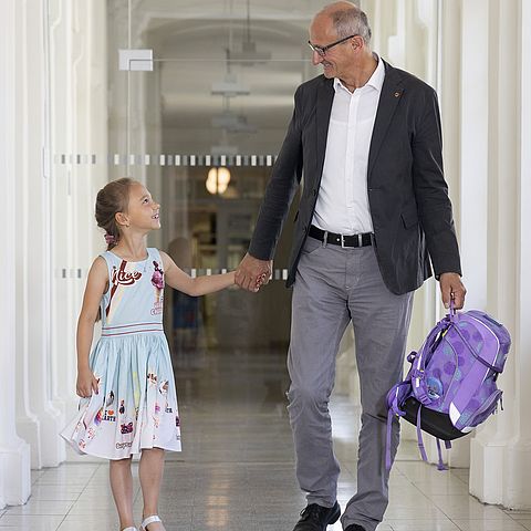 Anton Mattle mit Schultasche in der Hand neben einer Schülerin