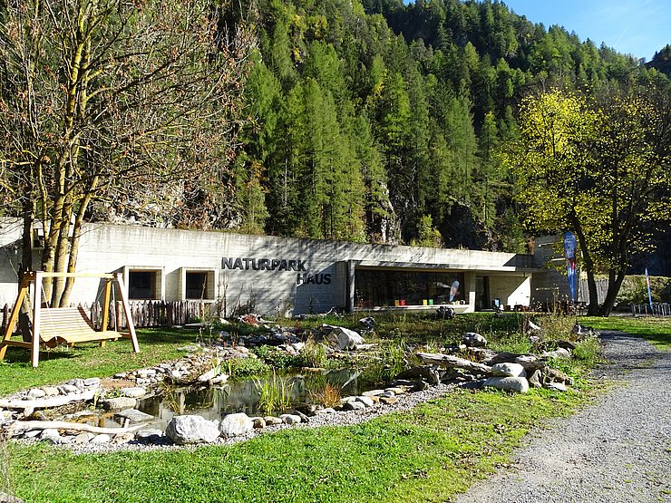 Naturparkhaus Ötztal umgeben von Bäumen.