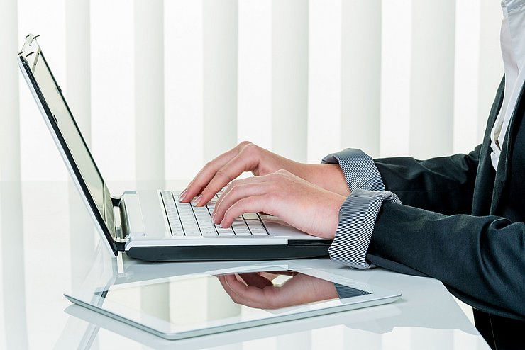 Frau im Büro mit Laptop Computer