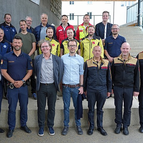 Gruppenfoto mit rund 20 Personen, einige in Uniform (Feuerwehr, Rettung...)
