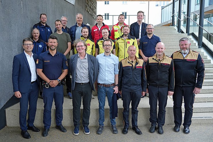 © Land Tirol/Pölzl Gruppenfoto mit rund 20 Personen, einige in Uniform (Feuerwehr, Rettung...)