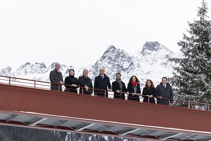 Gruppenfoto der TeilnehmerInnen auf einer Brücke mit Bergen im Hintergrund