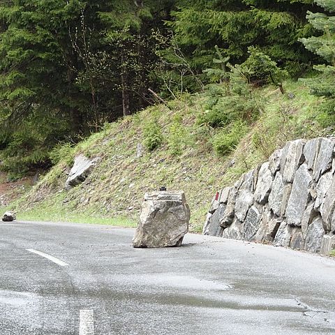 Ein etwa einem Kubikmeter großer Felsblock versperrt die Fahrbahn.