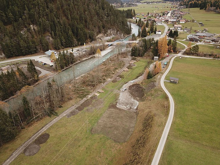 © Land Tirol/Reiter Gegenüber der Tankstelle Wolf werden alle Fichten entfernt, die Längsverbauung wird abgetragen. Das Lechufer wird in diesem Bereich neu strukturiert. Nach Abschluss der Grabungsarbeiten findet in diesem Bereich wieder eine Aufforstung statt .