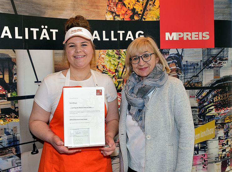 Arbeits- und Bildungslandesrätin Beate Palfrader gratuliert Sarah Berger zum "Lehrling des Monats Februar 2022" an ihrem Arbeitsplatz in Matrei in Osttirol.